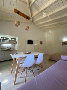 Habitación con mesa y 2 sillas blancas. en El IDEAL, en Pinamar