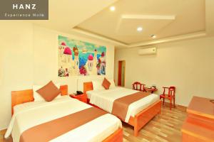 a hotel room with two beds and a table at HANZ HOPAPA Hotel Phu Quoc in Phu Quoc