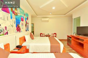 a bedroom with a bed and a flat screen tv at HANZ HOPAPA Hotel Phu Quoc in Phu Quoc