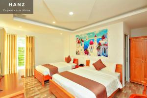 a bedroom with two beds and a painting on the wall at HANZ HOPAPA Hotel Phu Quoc in Phu Quoc