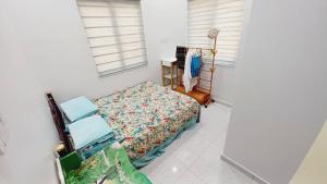 a bedroom with a bed and a desk and window at Aufa House in Padang Rengas