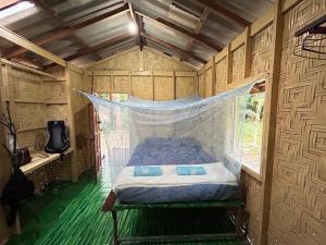 Ce lit se trouve dans une petite chambre dotée d'une moustiquaire. dans l'établissement sofee homestay(Bulone Island)langu Satun Thailand, à Ko Bulon Le