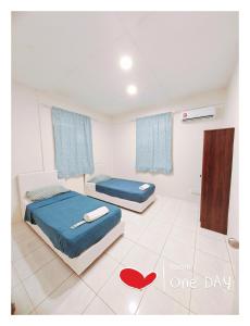um quarto com duas camas e um coração vermelho no chão em Richmond Residence em Kuching