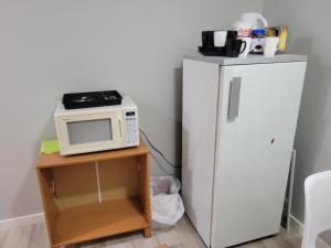 - un four micro-ondes sur une table à côté d'un réfrigérateur dans l'établissement Brand New 2 Bedroom Basement Suite with Wifi, à Edmonton