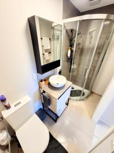 a white bathroom with a shower and a sink at Unique Estuary & Bird Apartment in Te Haumi Paihia in Paihia