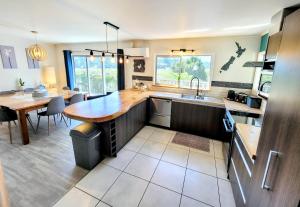 a kitchen with a wooden counter top and a table at Unique Estuary & Bird Apartment in Te Haumi Paihia in Paihia