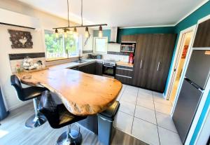 a kitchen with a wooden table and some chairs at Unique Estuary & Bird Apartment in Te Haumi Paihia in Paihia