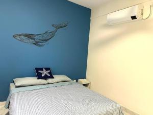 een slaapkamer met een bed met een walvisschilderij aan de muur bij Blue Ocean House 3br DatoOnn JB in Johor Bahru