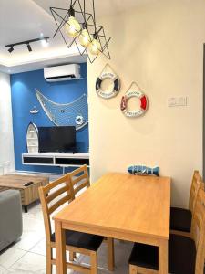een eetkamer met een houten tafel en stoelen bij Blue Ocean House 3br DatoOnn JB in Johor Bahru