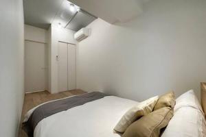 1 dormitorio con 1 cama blanca en una habitación en bHOTEL Art Bldg - Modern 2BR City Center for 8ppl en Ōsukachō