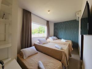 a hotel room with two beds and a window at JPN18 - Duplex em condomínio fechado próx. à praia in Natal