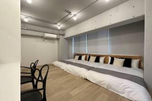 a bedroom with a large bed and a chair at Art Bldg by b hotel - Stylish Apartment Very Good Location in Ōsukachō