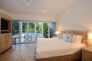 a bedroom with a large white bed and a balcony at The Condo - A Spacious Villa Near Beach and Town in Port Douglas +42 photos