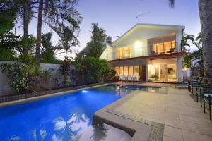 a house with a swimming pool in front of a house at The Condo - A Spacious Villa Near Beach and Town in Port Douglas