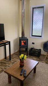 a living room with a coffee table and a fireplace at Cabaña Alto Arrayán in Pucón