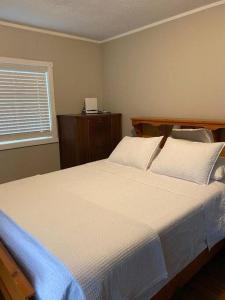 a bedroom with a bed with white sheets and a window at Bluewater Delight in Sarnia