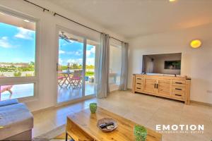 a living room with a couch and a tv at Appartement 2 chambres Blue Marine Maho Sxm in Maho Reef