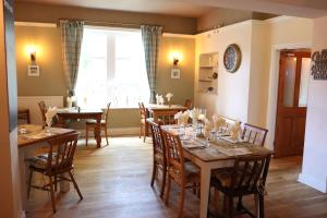 a dining room with tables and chairs and a window at The Tollemache Arms in Buckminster