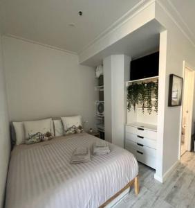 a white bedroom with a large bed and a dresser at Instaworthy views Ace Location Walk Everywhere in Melbourne