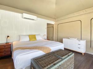 a bedroom with a large bed and a dresser at Magnetic Glamping Tent 7 in Nelly Bay