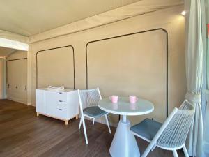 Habitación con mesa, 2 sillas y escritorio. en Magnetic Glamping Tent 7, en Nelly Bay