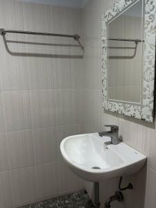 W łazience znajduje się umywalka i lustro. w obiekcie New Mekar Jaya Hotel w mieście Legian