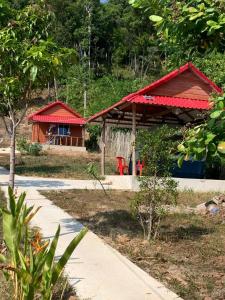 a house with a red roof next to a sidewalk at Maloop Cafe Bungalow in Koh Rong Island