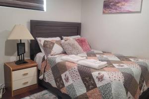 a bedroom with a bed with a quilt on it at Two luxury bedrooms in the basement in Winnipeg