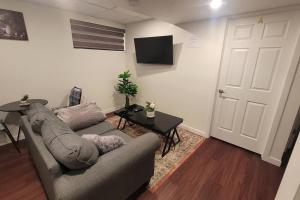 ein Wohnzimmer mit einem Sofa, einem Tisch und einer Tür in der Unterkunft Two luxury bedrooms in the basement in Winnipeg