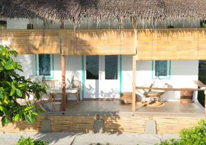 Katiet的住宿－Mentawai Katiet Beach House, Lance's Right HTS，一个带桌子和茅草屋顶的度假胜地