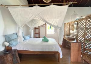 a bedroom with a bed with a canopy at Mentawai Katiet Beach House, Lance's Right HTS in Katiet