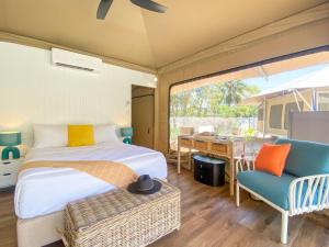 a bedroom with a bed and a table and chairs at Magnetic Glamping Tent 10 in Nelly Bay