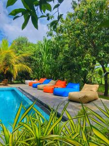 a row of pillows sitting next to a swimming pool at Richards Cabanas in Tissamaharama