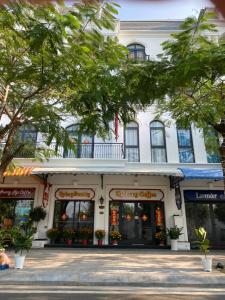 a white building with flowers in the windows at UY LONG Homestay Grand World Phú Quốc in Phú Quốc