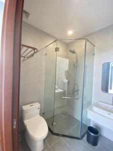 uma casa de banho com um WC e uma cabina de duche em vidro. em UY LONG Homestay & Coffee em Duong Dong
