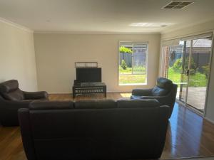 a living room with two couches and a tv at Elegant master bedroom with private bathroom in Point Cook