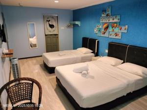 Un dormitorio con dos camas y una pared azul. en May Room Semporna, en Semporna
