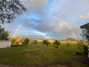 a rainbow in the sky over a field at George Gardens in Ramona