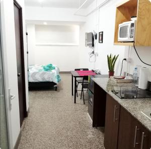 uma cozinha com uma mesa e uma cama num quarto em Apto moderno zona 1 em Guatemala