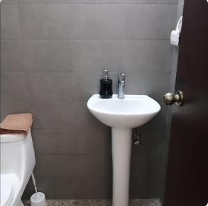 a bathroom with a white sink and a toilet at Apto moderno zona 1 in Guatemala