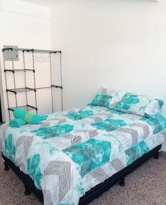 uma cama com uma colcha e almofadas em Apto moderno zona 1 em Guatemala