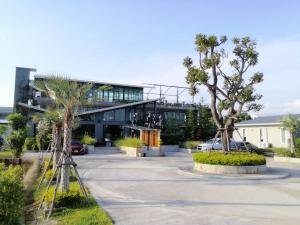 un bâtiment avec une voiture garée sur un parking dans l'établissement The River Palm Resort, à Bang Hia