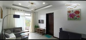 ein Wohnzimmer mit Sofa und Fenster in der Unterkunft Ayee Condo in Baguio City