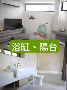 uma casa de banho com um lavatório, um WC e uma televisão em JOY tainan No.1 em Tainan