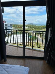 1 dormitorio con vistas a un balcón en Khách sạn AN THỊNH 2, en Doc Let