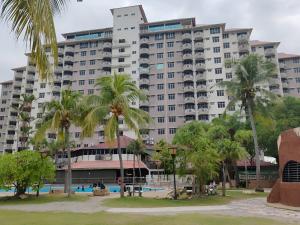 un gran edificio con palmeras delante en GLORY BEACH RESORT, PD @ Ocean Breeze (seaview) 3 Bedroom Apartment en Port Dickson