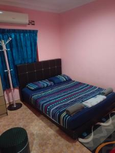 MieHomestay Binjai Rendah في Bukit Payong: غرفة نوم بسرير في غرفة بها مصباح