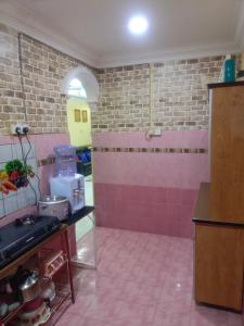 une cuisine avec des murs carrelés roses et un sol rose dans l'établissement MieHomestay Binjai Rendah, à Bukit Payong