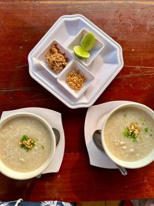 a table with two bowls of soup and a plate of food at Green Hill Homestay, Restaurant & Treķking in Banlung