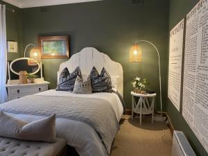 a bedroom with a bed with a white headboard at The Miner's Rest in Stawell